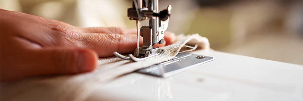 Nahaufnahme aus dem hauseigenen Nähatelier: Eine Nähmaschine während der Arbeit.