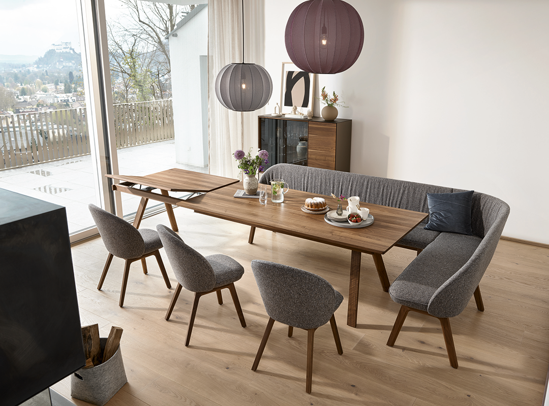 Esstisch Taso von Team 7 aus Naturholz im Esszimmer mit Stühlen und einer Eckbank.