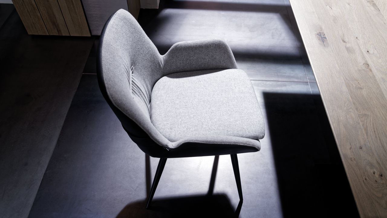 Ein gepolsterter Stuhl der Serie Galvino von Voglauer in grau.